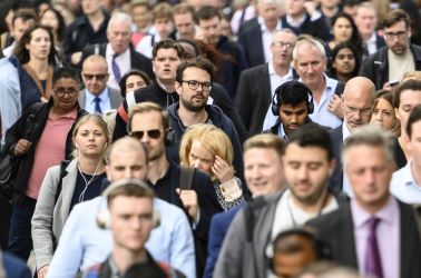 Crowd of consumers walking in a busy urban setting.